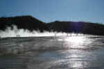 At Lower Geyser Basin, people on the boardwalk are backlit by the steam.